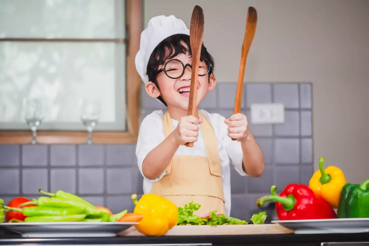 Kid having fun learning how to cook