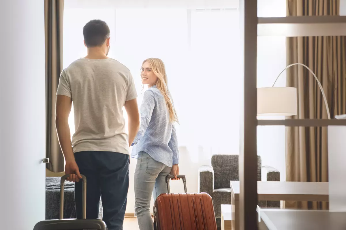 Two people checking into a hotel room.