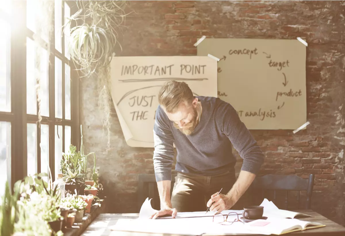 Man working on blueprints at a desk.