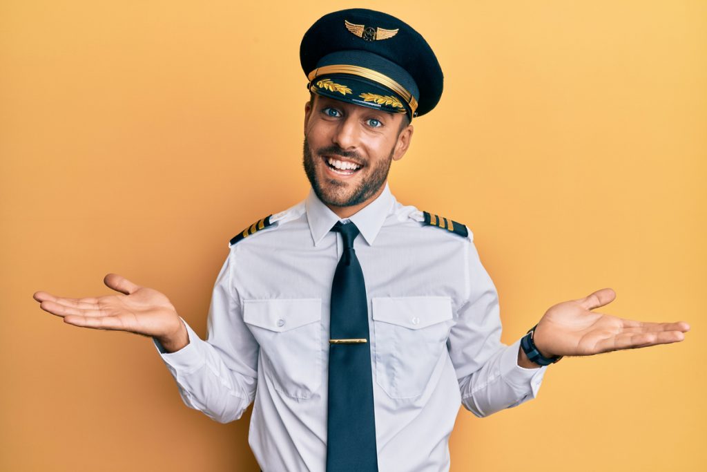 Pilot standing in front of an orange background.