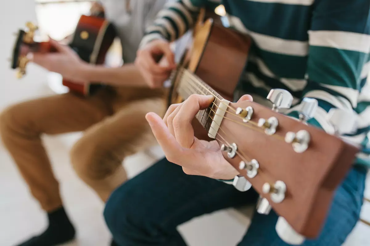 Two people playing guitars.