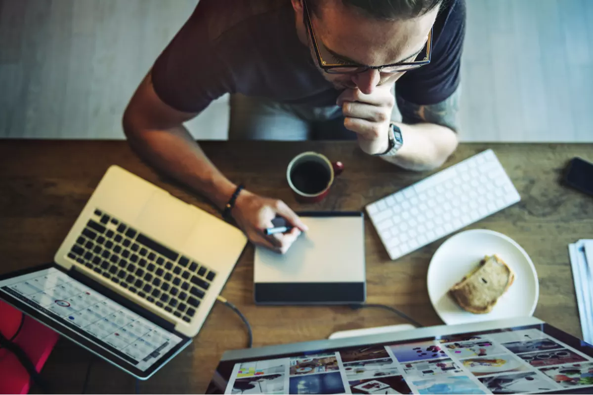 man sitting on a desk in front of a laptop