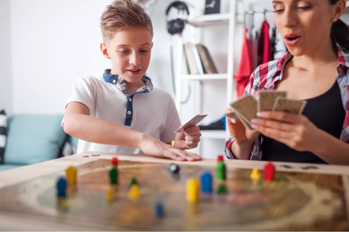 A boy and his mother playing a board game.