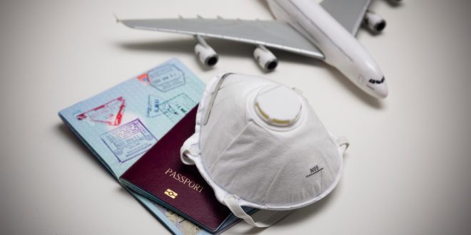A miniature airplane, mask, and passport.