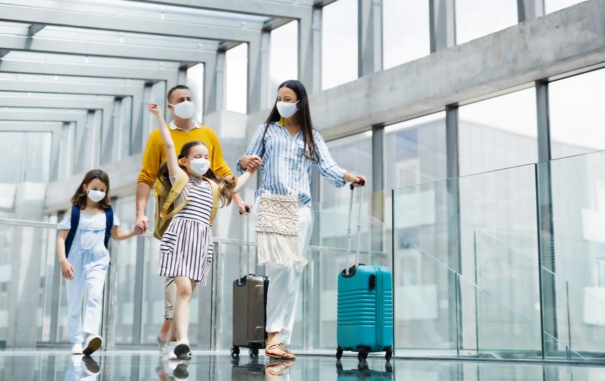 A family at an airport wearing face masks. 