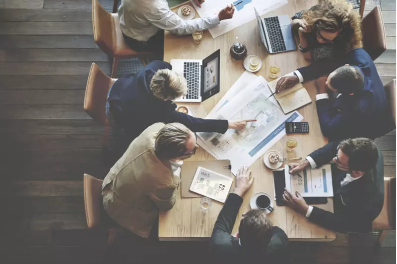 Team meets at a conference table in an office.