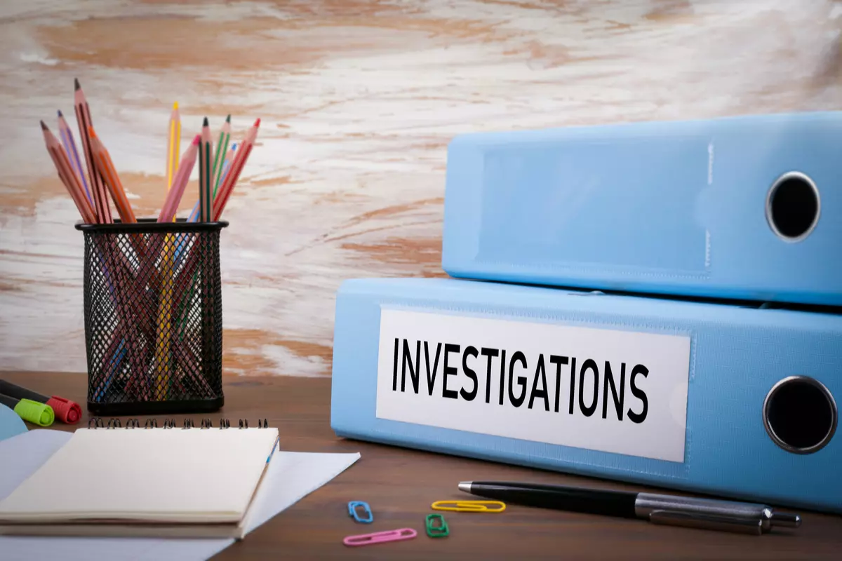 A tax fraud investigations binder sitting on a desk. 