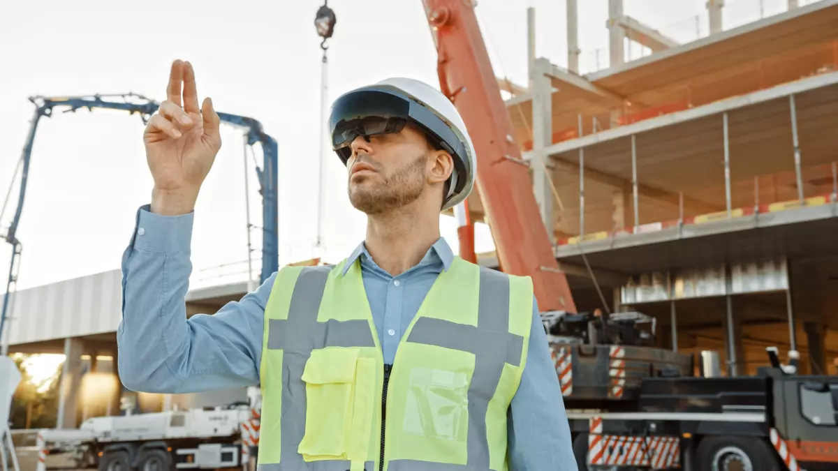 Construction worker uses augmented reality glasses to plan project on site.