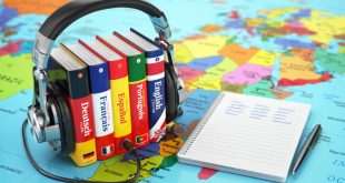 A world map with books of languages and earphones