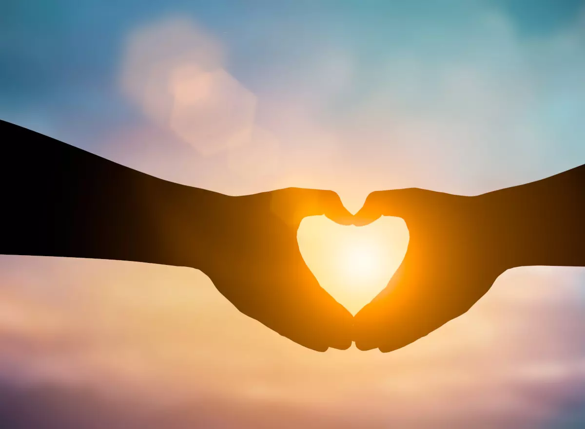 A silhouette of hands making a heart shape.