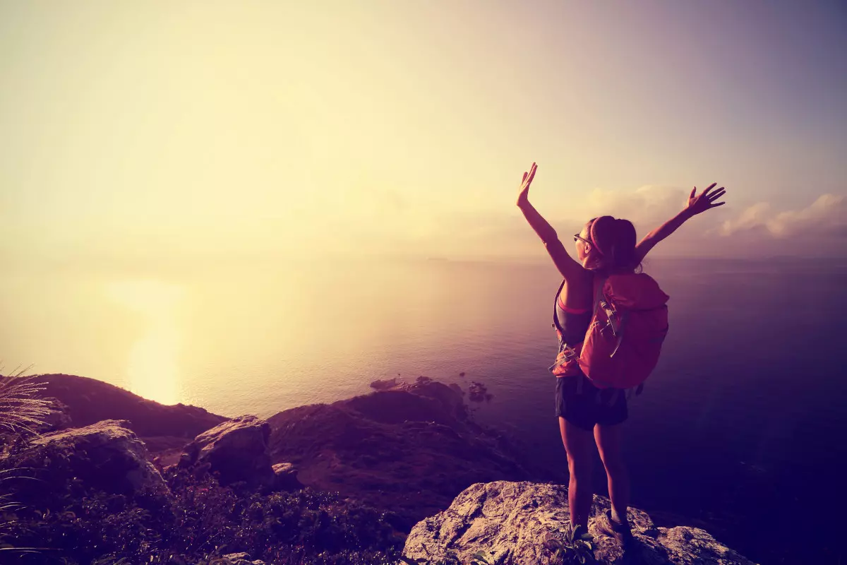 A woman hiking up a mountain.