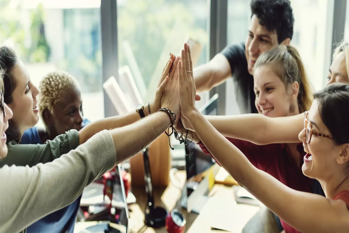 Team high fiving each other after successful teamwork