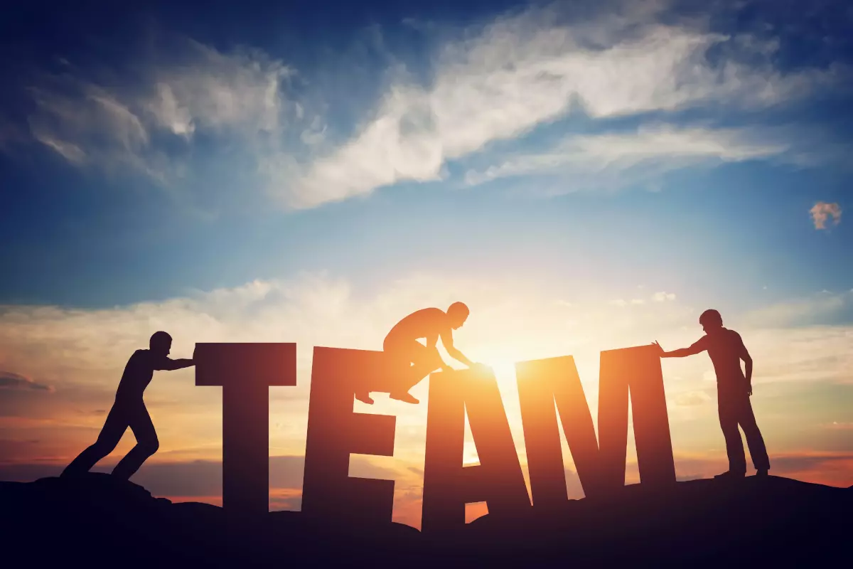 Men holding Team sign in the sunset