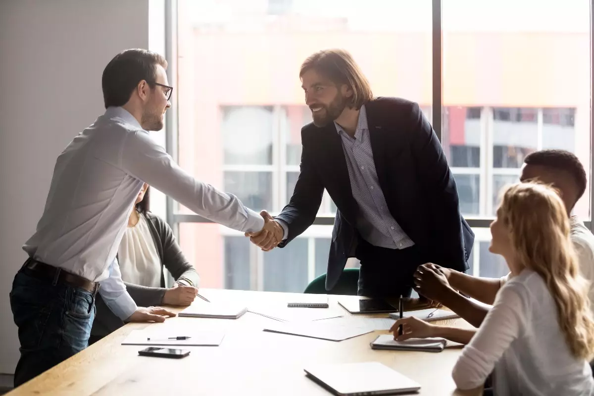 Business professionals shaking hands in meeting.