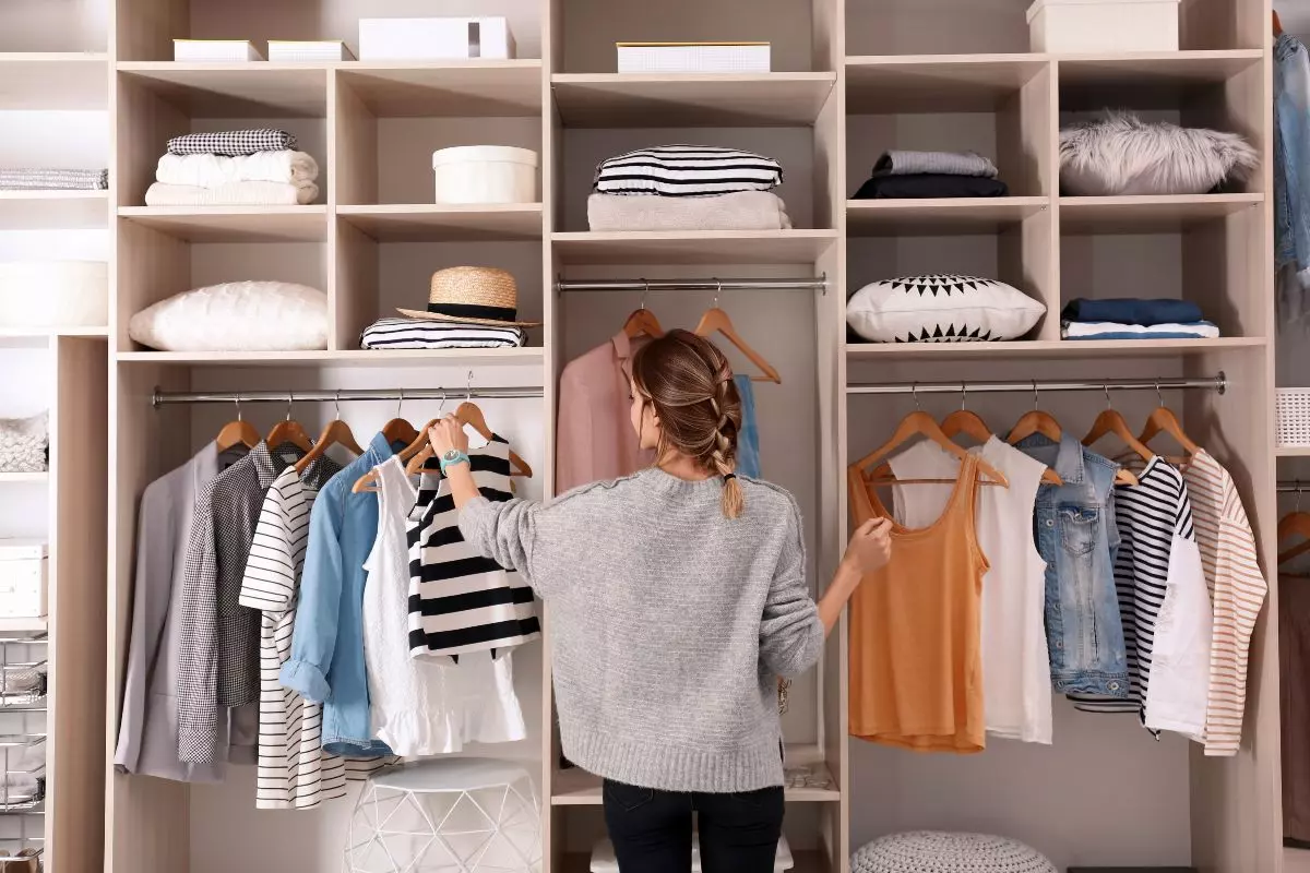 Young adult looking through closet.