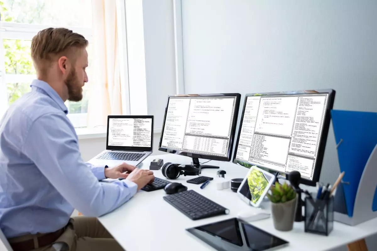 Computer technician working on multiple computers in home office.