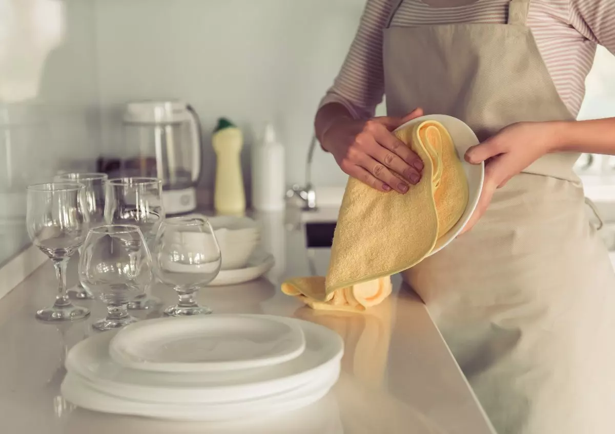 Hand drying dishes.