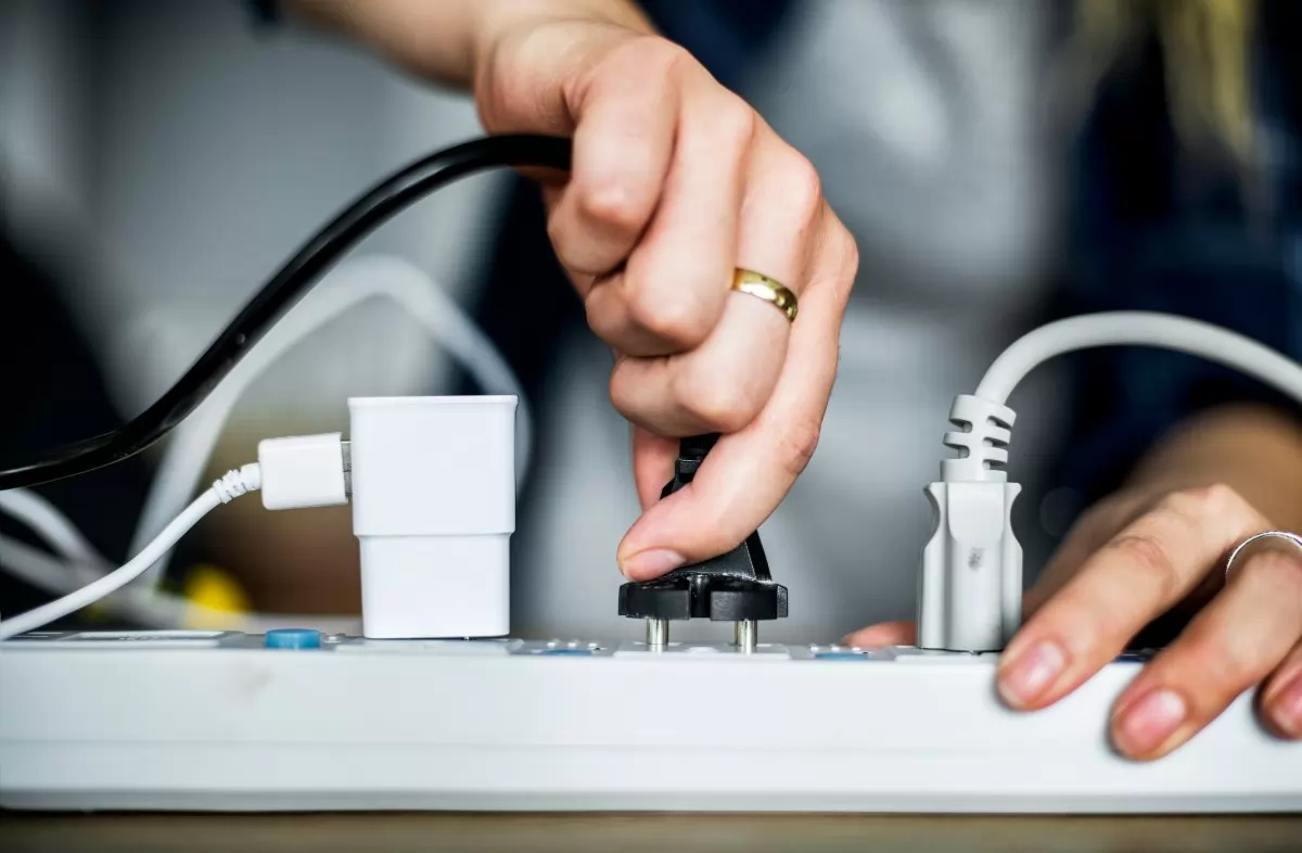 Plugging cord into power strip.