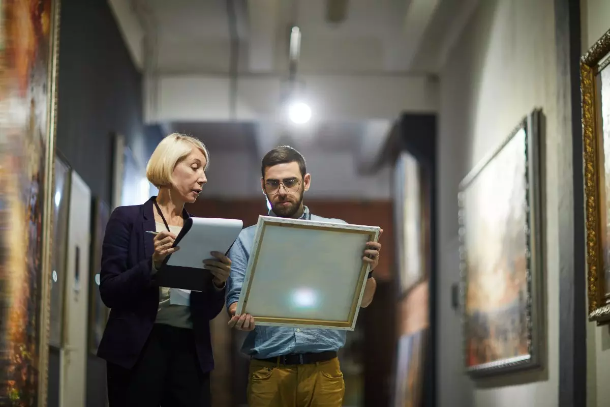 Art curators examining a painting