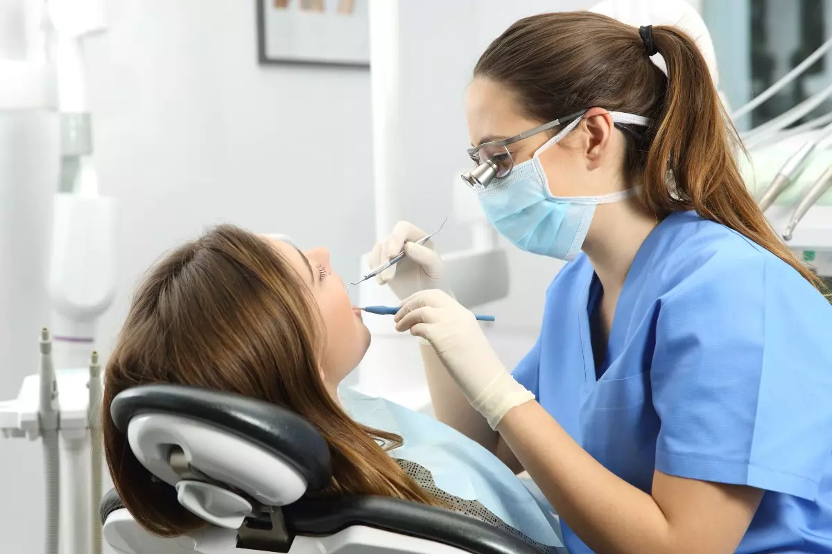Dental hygienist cleaning client's teeth