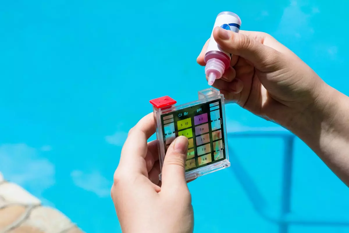 Close up on pool cleaner using chemicals to test the water 