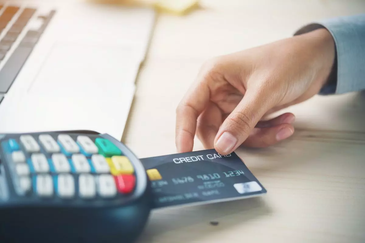 Close up on individual using a credit card with a chip.