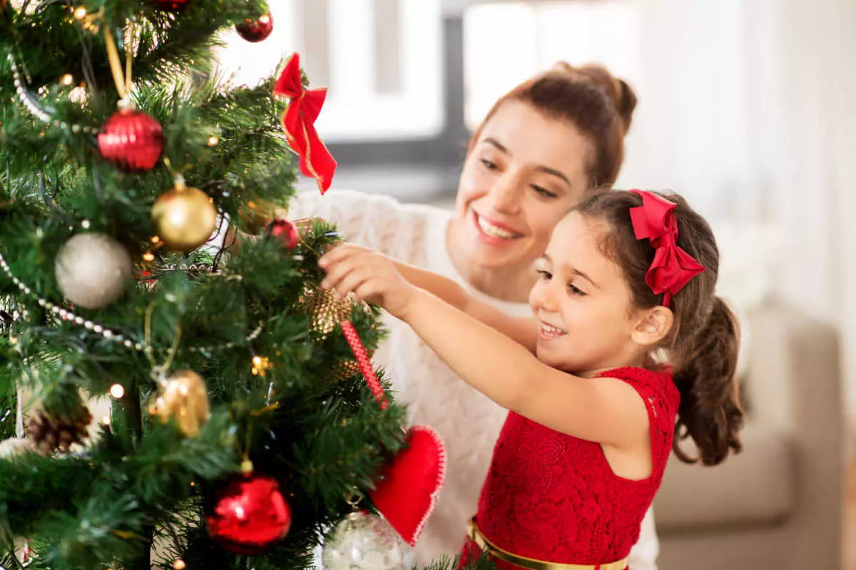 Mother and daughter decorating Christmas tree