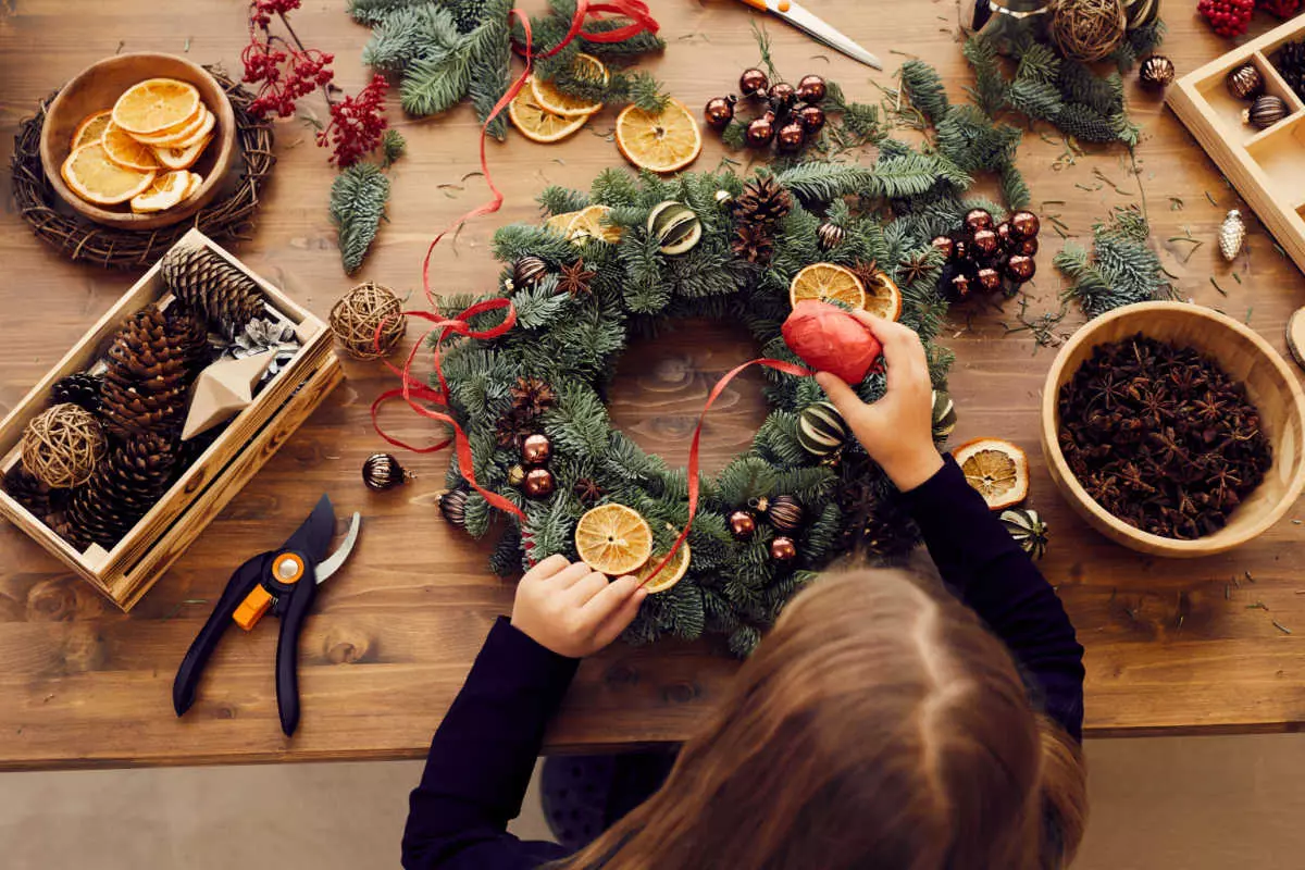Overhead view of child decorating holiday wreath