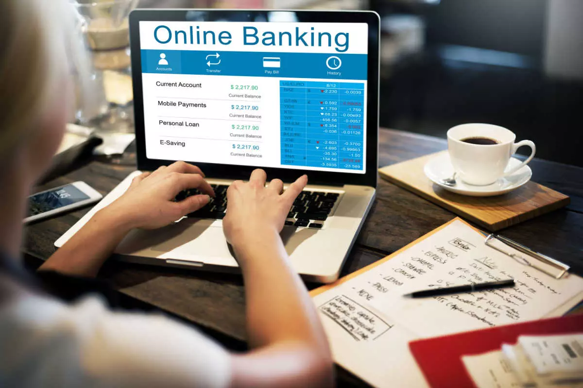 Individual using online banking to pay bills and save