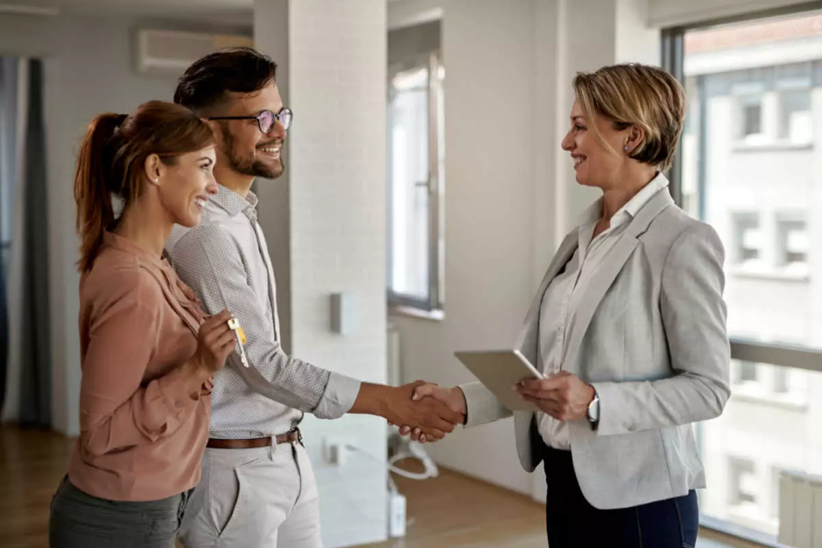 Couple shaking hands with real estate agent 