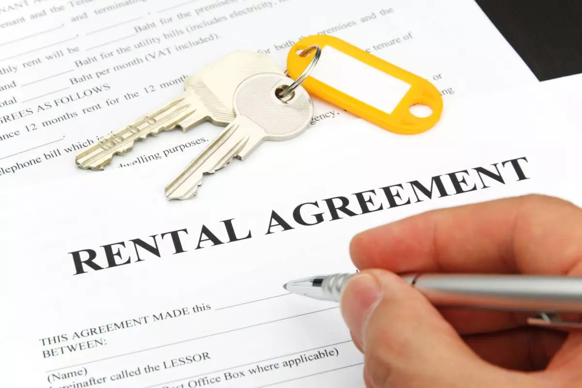 Close up on tenant signing rental agreement paperwork