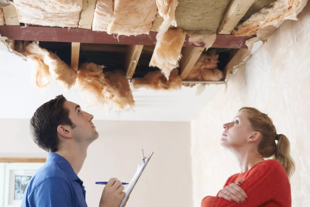 Contractor and homeowner inspecting ceiling 