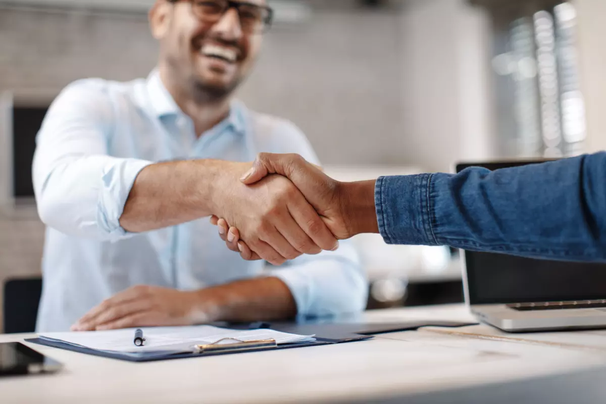 Business partners shaking hands and smiling