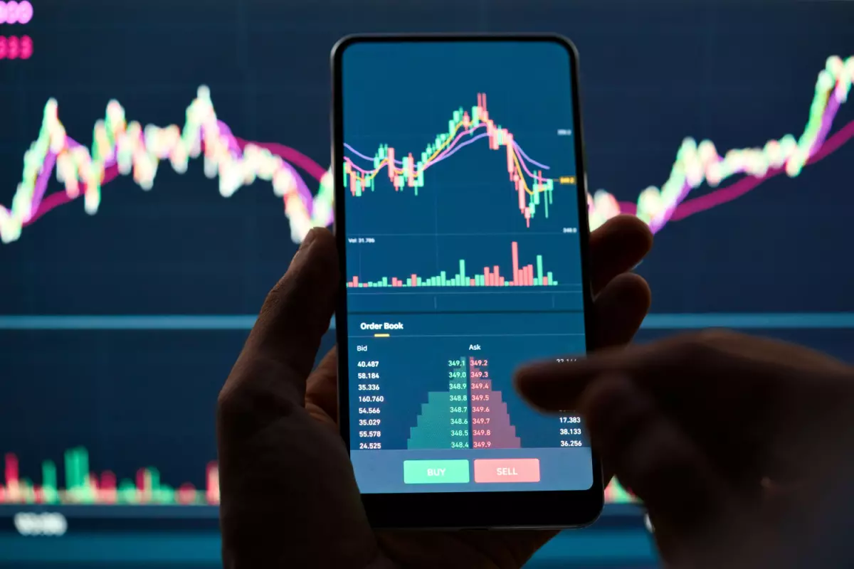 man checking on mobile what happens to stock market during recession