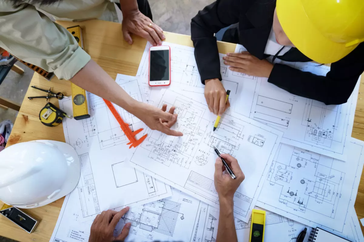 Overhead view of group of contractors reviewing blueprint