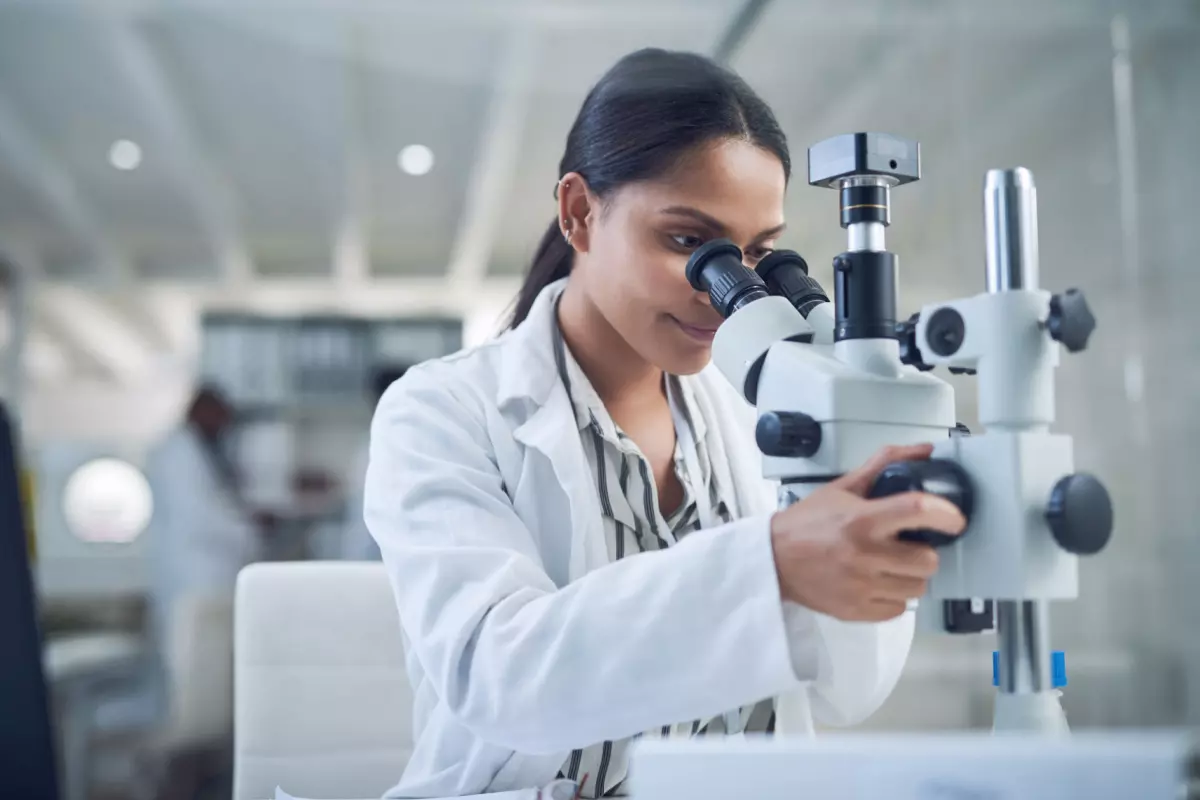 Lab technician looking in microscope