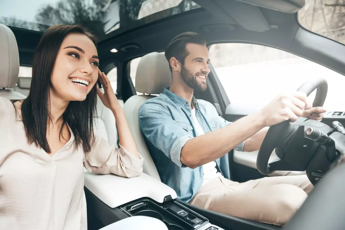 Young couple smiling in rented car